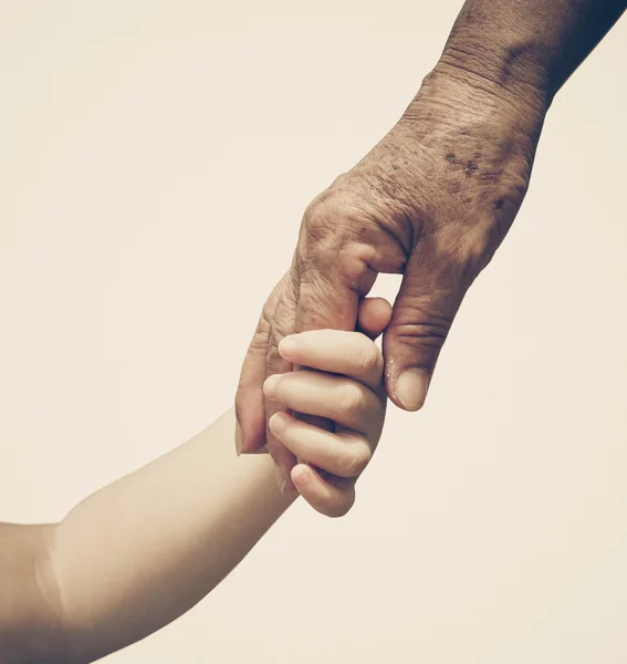 Маленький ребенок трогает старую руку — стоковое фото