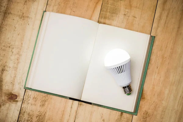 LED lightbulb on open book — Stock Photo, Image