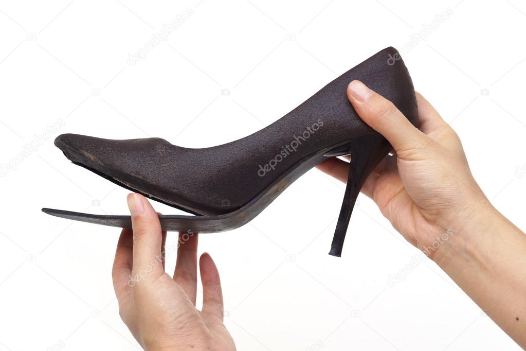 Female hand holding broken shoe