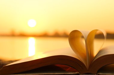 Kalp günbatımı arka plan üzerinde kitap sayfalarından
