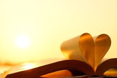Kalp günbatımı arka plan üzerinde kitap sayfalarından