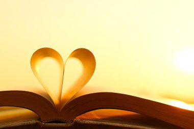 Kalp günbatımı arka plan üzerinde kitap sayfalarından