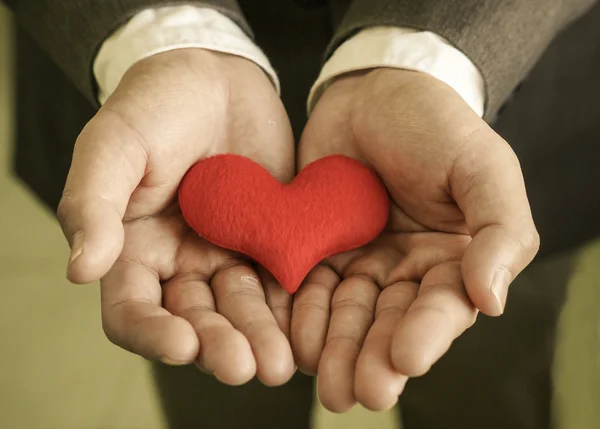 Businessman gives a red heart — Stock Photo, Image