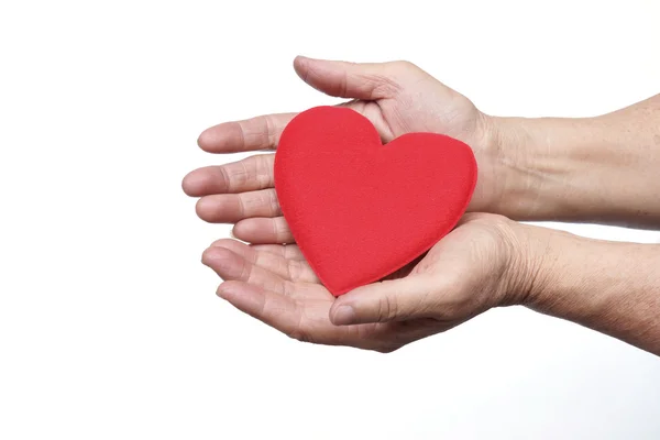 Manos sosteniendo un corazón rojo — Foto de Stock