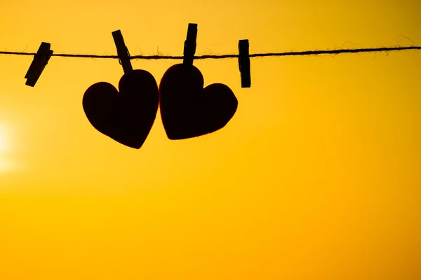 Silhouette of hearts hanging on rope — Stock Photo, Image