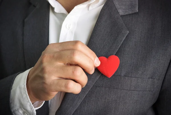 El hombre de negocios sostiene el corazón rojo — Foto de Stock