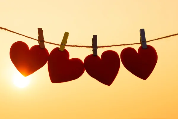 Silhouette of hearts hanging on rope — Stock Photo, Image