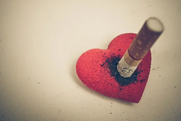 Cigarette burnt a red heart — Stock Photo, Image