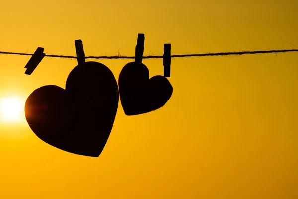 Silhouette of hearts hanging on rope — Stock Photo, Image