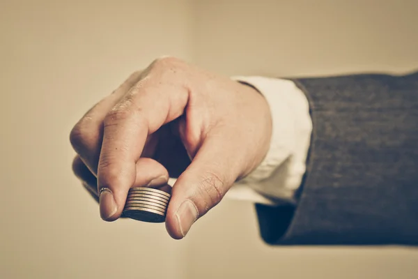 Mão de um empresário segurando moedas — Fotografia de Stock