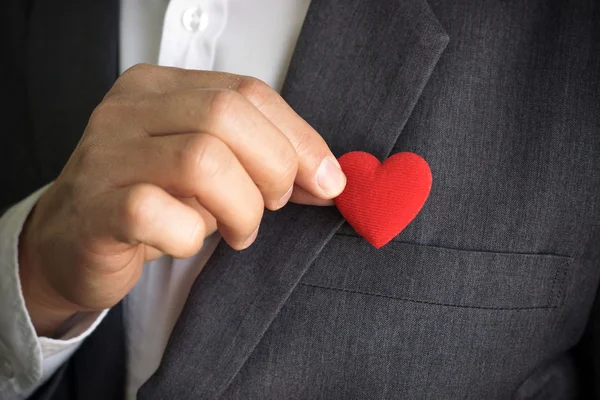 El hombre de negocios sostiene el corazón rojo — Foto de Stock