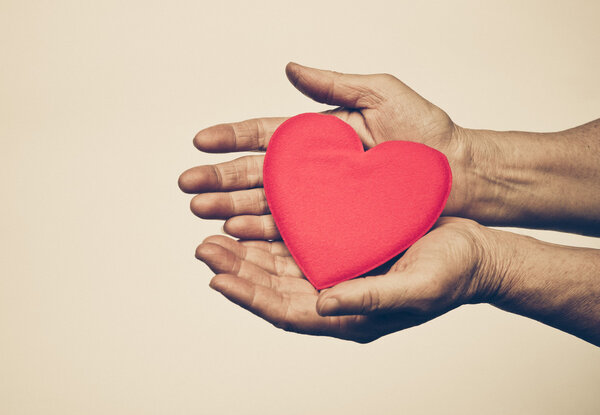Руки держат красное сердце