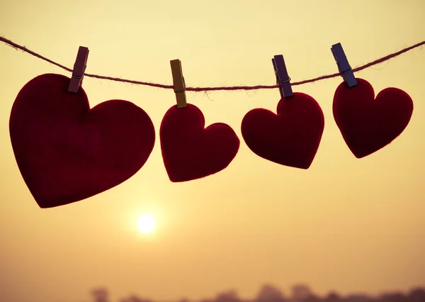 Silhouette of hearts hanging on rope — Stock Photo, Image