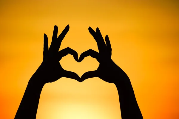 Mani che formano una forma di cuore — Foto Stock