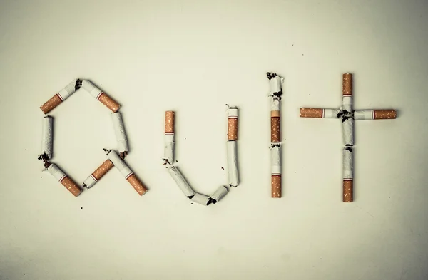 Zlomené cigarety, které jsou uspořádány jako slovo ukončit — Stock fotografie
