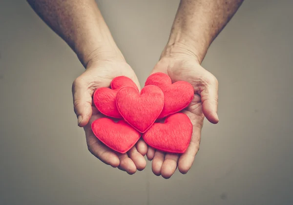 Mâini care țin inimile roșii — Fotografie, imagine de stoc