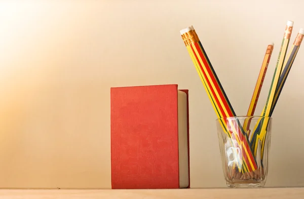 Un libro rosso con matite — Foto Stock