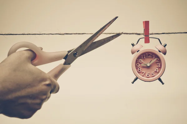 Hand schneidet ein Seil mit einer Uhr — Stockfoto