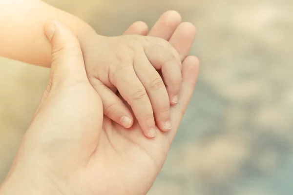 Mão de adulto segurando a mão de um bebê — Fotografia de Stock