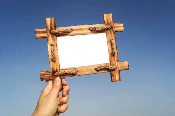 Mano sosteniendo un marco de madera — Foto de Stock