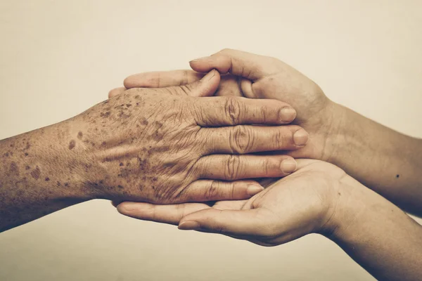 Weibliche Hände berühren alte weibliche Hand — Stockfoto