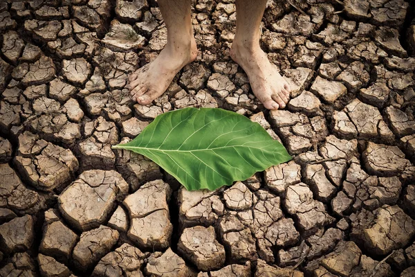 Man die op een droge, gebarsten aarde — Stockfoto