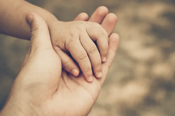 Mão de adulto segurando a mão de um bebê — Fotografia de Stock