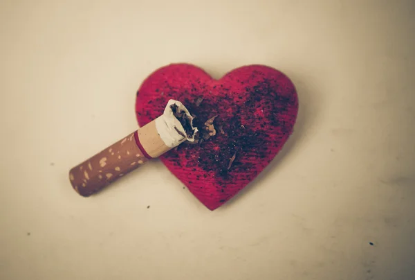 Cigarette burnt a red heart — Stock Photo, Image