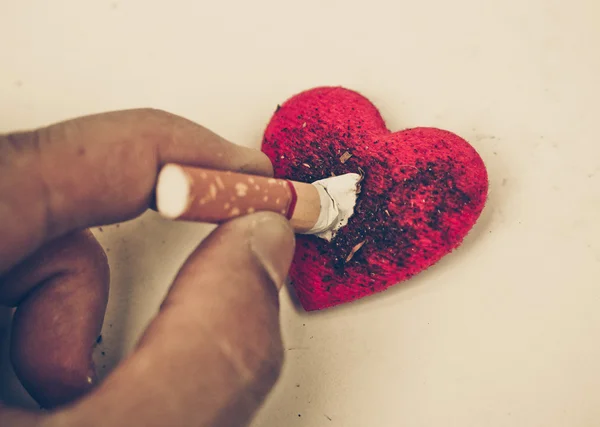 Cigarette burnt a red heart — Stock Photo, Image