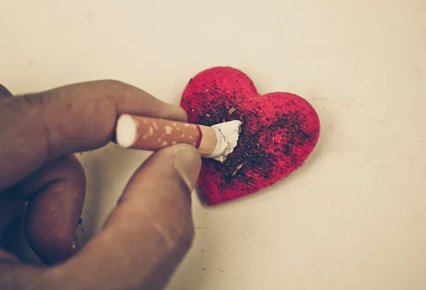 Cigarette burnt a red heart — Stock Photo, Image