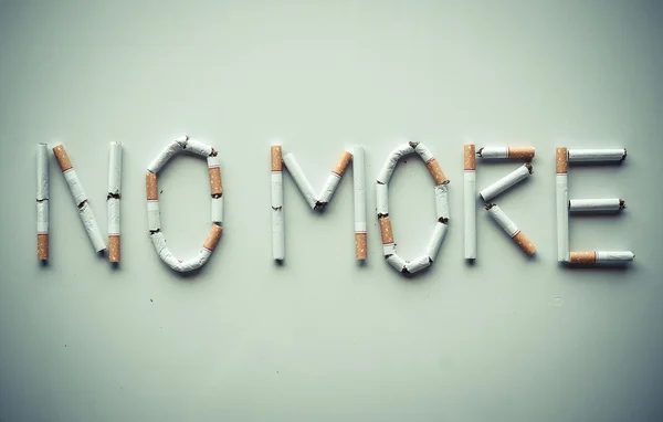 Cigareta uspořádány jako slovo více — Stock fotografie