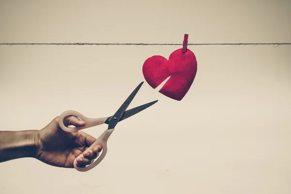 Forbici che cercano di tagliare un cuore rosso — Foto Stock