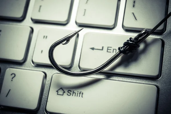 A fish hook on computer keyboard — Stock Photo, Image