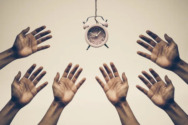 Hands chasing, fighting to get a clock — Stock Photo, Image