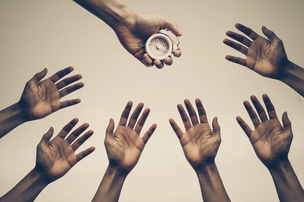 Manos persiguiendo, luchando para conseguir un reloj — Foto de Stock