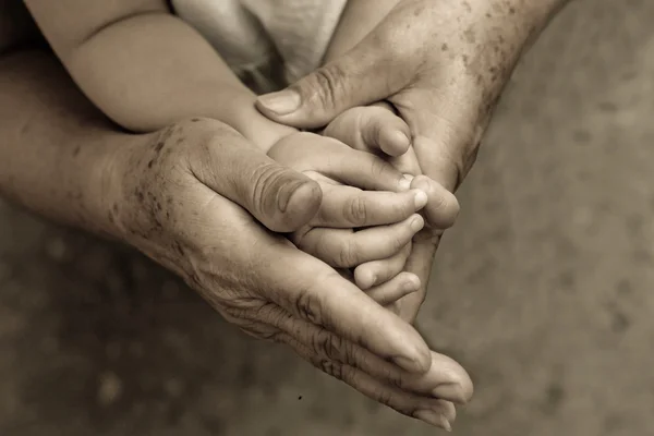 Alte Hände halten junge Hand — Stockfoto