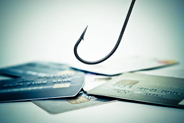 Рыбный крючок над грудой кредитных карт — стоковое фото