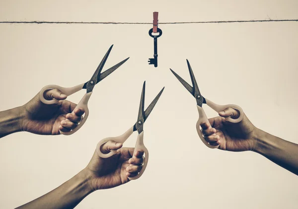 Mãos com tesoura tentando cortar uma corda — Fotografia de Stock