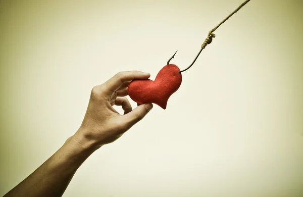 Hand catching a red heart — Stock Photo, Image