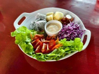 Beyaz tabak sebze ve meyve salatası.