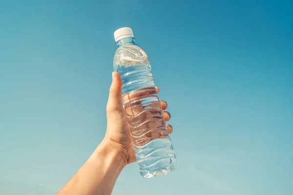 Mão segurando uma garrafa de água — Fotografia de Stock