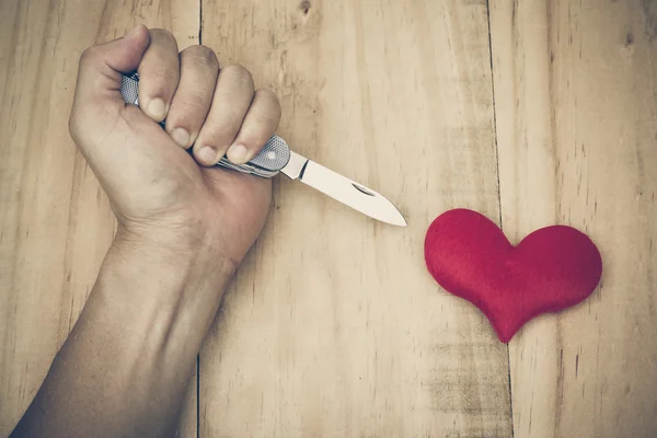 Couteau poignardant dans un cœur rouge — Photo