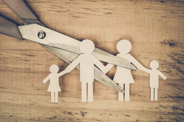 Scissors cutting paper cut of family — Stok fotoğraf