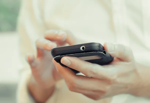 Mano de un hombre de negocios usando un teléfono inteligente — Foto de Stock