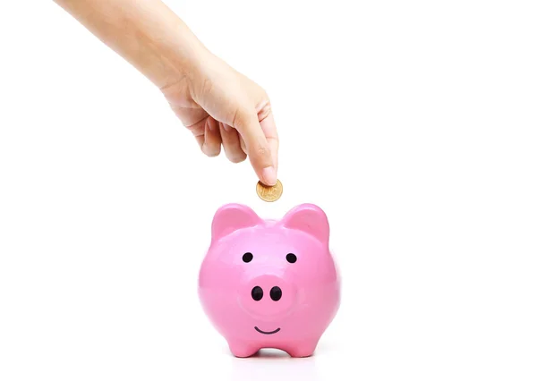 Mão economizando dinheiro em rosa porquinho banco — Fotografia de Stock
