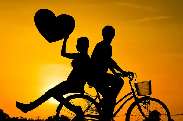 Silhouette di un uomo e una donna in bicicletta — Foto Stock