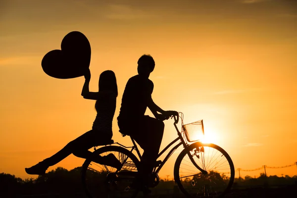 男と自転車に乗る女性のシルエット — ストック写真