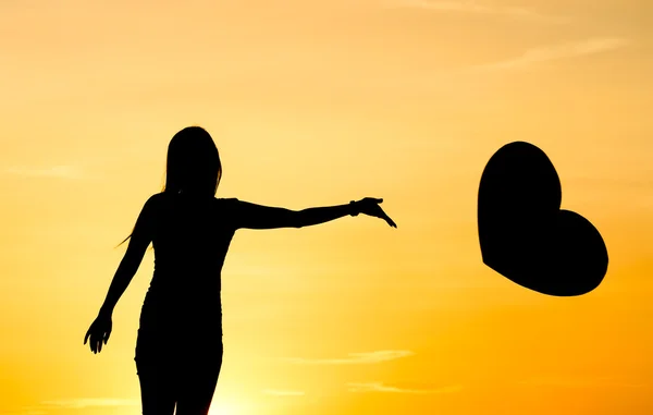 Una mujer lanzando un camino un gran corazón — Foto de Stock