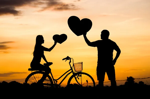 Silhueta de um homem e uma mulher andando de bicicleta — Fotografia de Stock