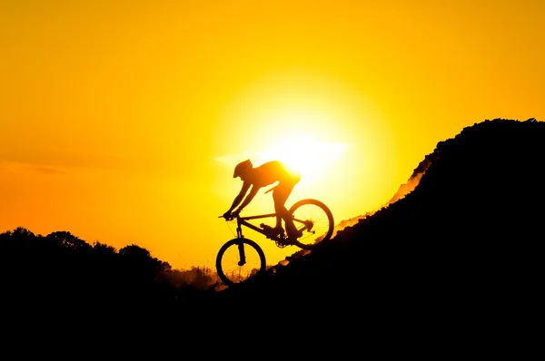 Ciclista de montaña montando en la montaña — Foto de Stock